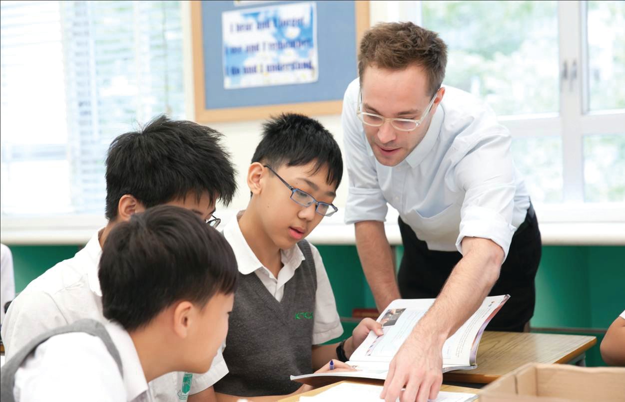 A TEFL teacher helping high school students with the task in English